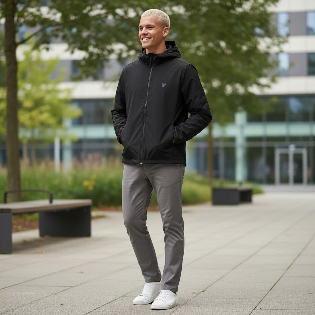 WILDVINE Clothing Co. model wearing a black Lyle & Scott nylon zip-through hooded jacket with grey trousers.