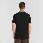 Back view of a man wearing a jet black WILDVINE Clothing Co. tipped track polo shirt with a striped collar.