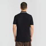 Back view of a man wearing a jet black WILDVINE Clothing Co. tipped track polo shirt with a striped collar.