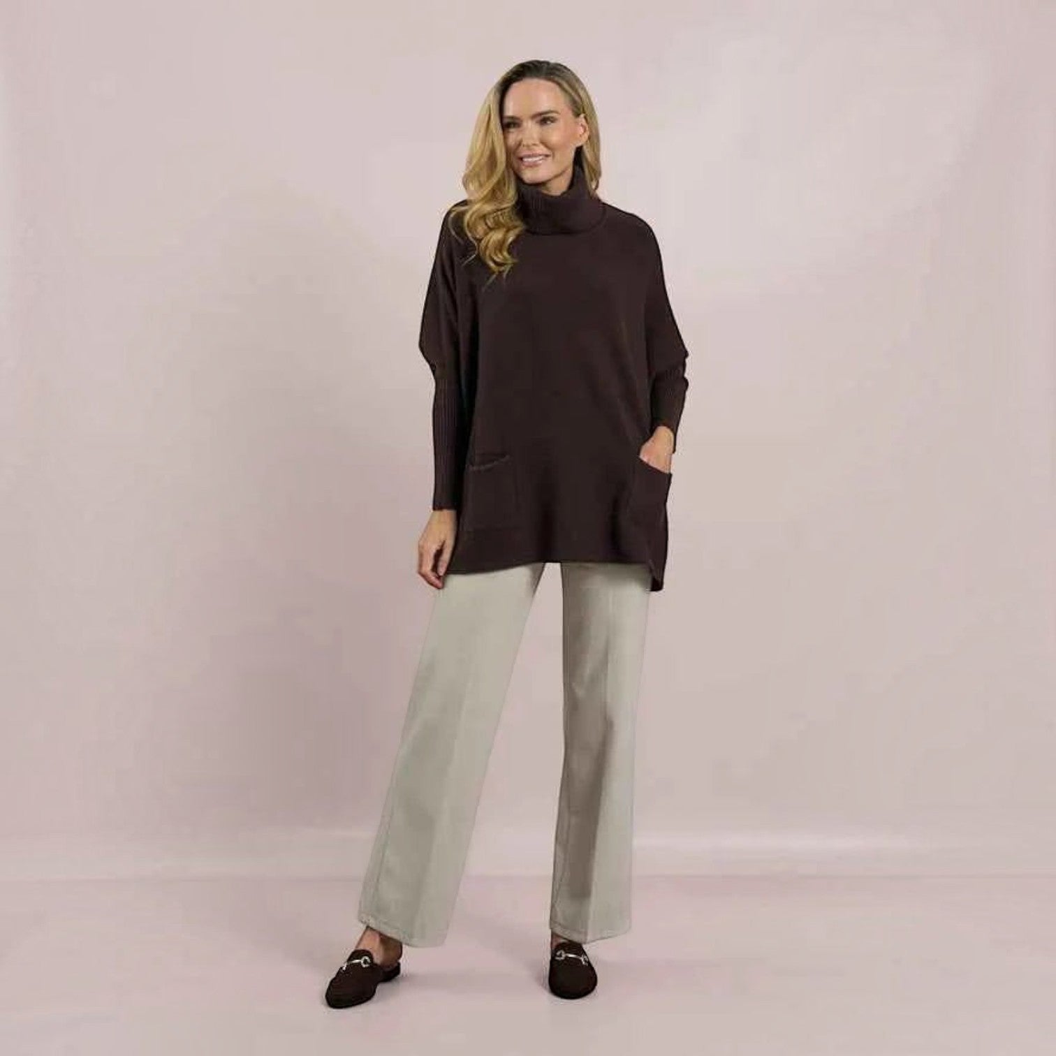 WILDVINE Clothing Co. model wearing a brown D.E.C.K. by Decollage roll neck knit sweater with front patch pockets.