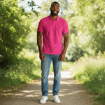 WILDVINE Clothing Co. men's grape pink 2-ply pique cotton polo shirt worn by a smiling man on a park path