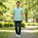 WILDVINE Clothing Co. light green short sleeve button-down shirt worn by a man walking in a park
