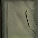 Close-up of a deep green padded jacket by WILDVINE Clothing Co. featuring a zippered pocket and durable fabric.