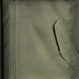 Close-up of a deep green padded jacket by WILDVINE Clothing Co. featuring a zippered pocket and durable fabric.
