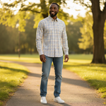 WILDVINE Clothing Co. man wearing a blue and black check long sleeve shirt with jeans in a sunny park setting