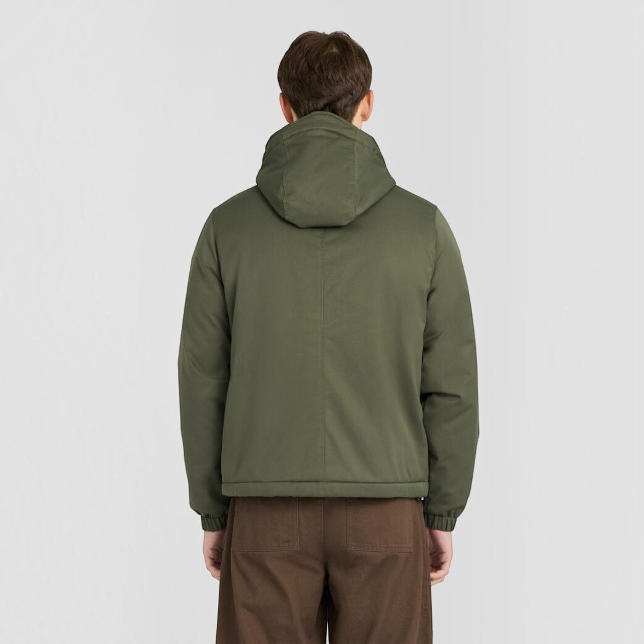 Back view of a man wearing a WILDVINE Clothing Co. olive green padded hooded zip-through jacket with elastic cuffs.