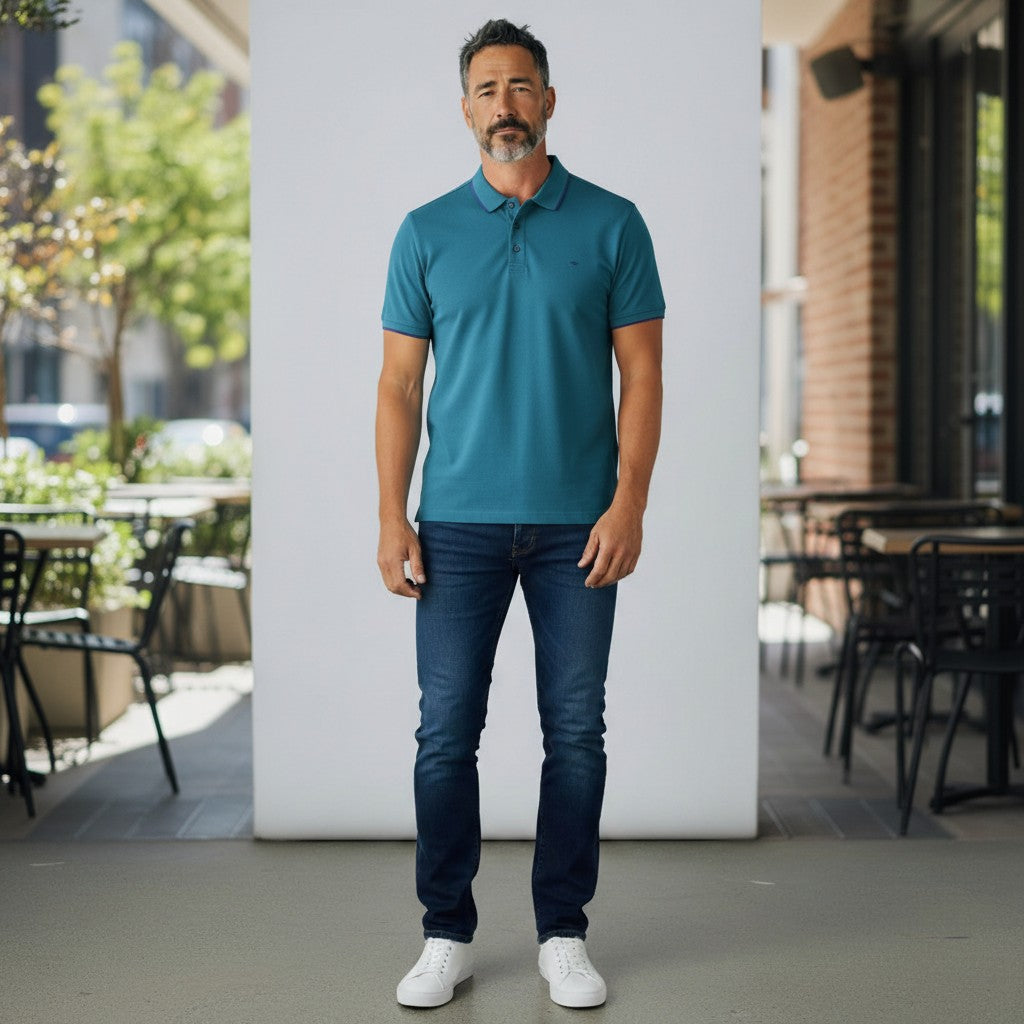 WILDVINE Clothing Co. teal 2-ply pique cotton polo shirt worn by a man with dark jeans and white sneakers