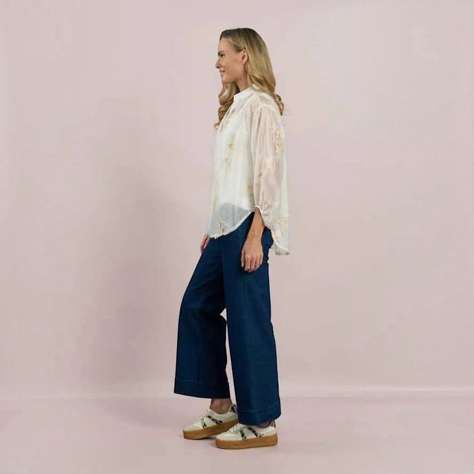 WILDVINE Clothing Co. white sheer blouse with floral embroidery, mandarin collar, and three-quarter sleeves on a model