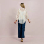 WILDVINE Clothing Co. white sheer blouse with floral embroidery, mandarin collar, and three-quarter sleeves, back view.