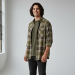 WILDVINE Clothing Co. Wrangler men's pesto green plaid western shirt worn over a t-shirt by a smiling man